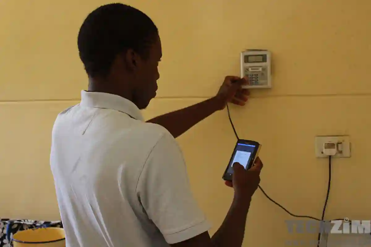  A man uses a mobile application to buy electricity tokens.